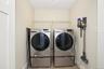 Dedicated 2nd floor laundry area featuring a front-loading washer and dryer set