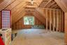 Exposed wood beam construction, unfinished flooring, window, and wood framing