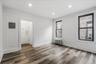 Empty room with dark wood finished floors, radiator heating unit, electric panel, recessed lighting, and a decorative wall