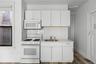 Kitchen featuring white appliances, white cabinetry, decorative backsplash, and dark wood-style floors