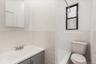 Bathroom featuring tile walls, vanity, wainscoting, and a shower