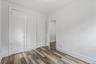 Unfurnished bedroom featuring wood finished floors and baseboards