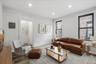 Living room with a decorative wall, wood finished floors, electric panel, and recessed lighting