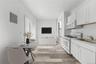 Kitchen featuring white appliances, light wood-style flooring, decorative backsplash, and white cabinetry