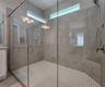 Master bathroom includes large walk-in  tiled shower, water closet, walk-in closet, dual sink vanity, granite countertops