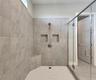 Master bathroom includes large walk-in  tiled shower, water closet, walk-in closet, dual sink vanity, granite countertops