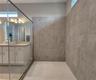 Master bathroom includes large walk-in  tiled shower, water closet, walk-in closet, dual sink vanity, granite countertops