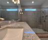 Master bathroom includes large walk-in  tiled shower, water closet, walk-in closet, dual sink vanity, granite countertops