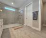 Master bathroom includes large walk-in  tiled shower, water closet, walk-in closet, dual sink vanity, granite countertops