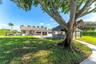 Expansive pasture featuring metal perimeter fencing, a covered storage structure with a metal roof, and established perimeter hedging