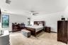 Neutral tile flooring and ceiling-mounted fan with integrated lighting