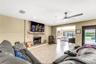 Living area featuring floor-to-ceiling stone fireplace, raised hearth, mantel, recessed lighting, and ceiling fan