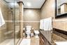Neutral-toned interior featuring tile flooring, a multi-blade ceiling fan with integrated lighting, and dual windows equipped with woven shades