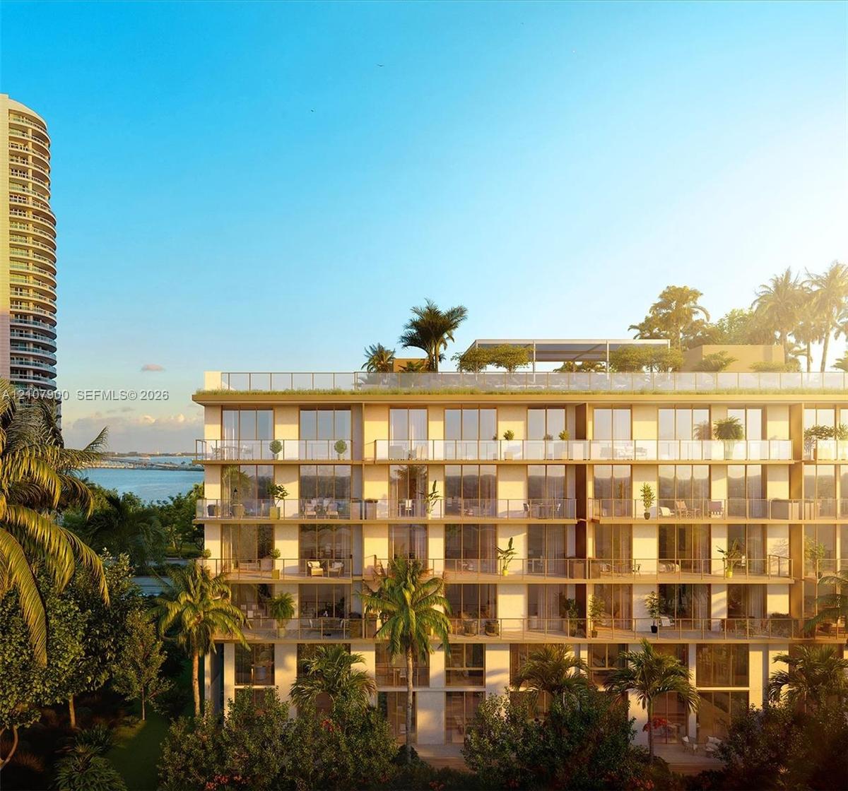 Multi-story residential building featuring floor-to-ceiling glass windows, individual private balconies with glass railings, and a landscaped rooftop 