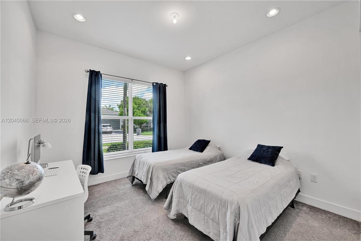 Neutral interior featuring wall-to-wall carpeting, recessed ceiling lighting, and a double-pane window with installed blinds