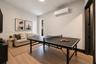 Textured charcoal accent wall featuring recessed ceiling lighting, light wood-finish flooring, and black window trim