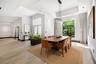 Tray ceilings with recessed lighting, wood-finish flooring, large-format windows, modern linear chandelier, and double-door entry