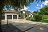 Single-story residence featuring a stucco exterior, clay tile roof, attached two-car garage, and a paver driveway with integrated turf strips