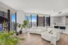 Floor-to-ceiling windows, wood-finish flooring, built-in kitchen breakfast bar, and open-concept layout