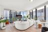 Floor-to-ceiling windows, wood-finish flooring, and wraparound glass balcony railings