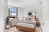 Neutral-toned walls, large window with urban exterior, and light-tone wood-finish flooring