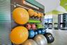 Fitness center featuring a wall-mounted equipment organization system, floor-to-ceiling windows, and patterned floor surfacing