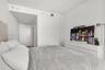 Neutral-toned interior space featuring recessed ceiling lighting, smooth white walls, and a dedicated hallway entry