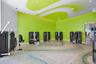 Fitness center featuring polished concrete flooring with a decorative inlay pattern, high ceilings with stylized graphic accents, and recessed lightin