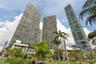 High-rise residential towers featuring glass-paneled facades, private balconies, and integrated landscaping with mature palm trees