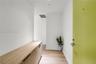 Entryway featuring a light-tone door with a modern lever handle, built-in wooden cabinetry with matte black hardware, and light wood-finish flooring