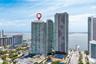 High-rise residential tower featuring glass-facade architecture, podium-level swimming pool, and dedicated court facilities
