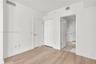 Interior space featuring wood-finish flooring, white walls, and a closet with double-panel doors