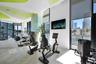 Fitness center featuring floor-to-ceiling windows, polished concrete flooring, custom graphic ceiling detail, and integrated solar shades