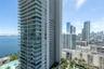 High-rise tower featuring floor-to-ceiling glass windows, expansive private wraparound balconies, and a reinforced concrete facade