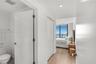 Floor-to-ceiling windows with water backdrop, wood-finish flooring, and recessed ceiling lighting