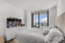 Floor-to-ceiling sliding glass door, private balcony with metal railing, and light-toned flooring