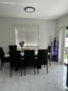 Large-format stone-finish tile flooring, recessed circular ceiling lighting, and vertical window blinds
