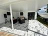Covered outdoor patio featuring large-format stone-look tile flooring, recessed ceiling lighting, and double glass-paned doors