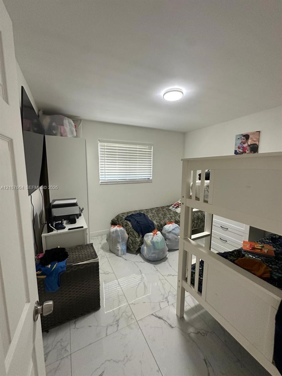 Large-format polished tile flooring, flush-mount ceiling lighting, and horizontal window blinds