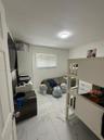 Large-format polished tile flooring, flush-mount ceiling lighting, and horizontal window blinds