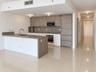 Open-concept interior featuring large-format tile flooring and a kitchen with dark wood-finish cabinetry, a peninsula counter, and integrated stainles