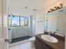 Interior space featuring polished tile flooring, neutral walls, and a full-height window with water and skyline scenery