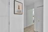 Hallway featuring wood-finish flooring and a closet with white louvered bi-fold doors