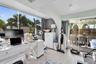 Floor-to-ceiling windows, light-toned wood-finish flooring, and arched architectural detailing