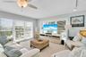 Living area featuring multi-panel windows with adjustable horizontal blinds, ceiling-mounted fan with integrated lighting, and track lighting fixtures