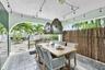 Covered patio featuring ceramic tile flooring, built-in stainless steel outdoor kitchen, arched architectural detailing, and decorative woven pendant 