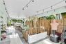 Covered patio featuring white tile flooring, arched structural detailing, and overhead string lighting