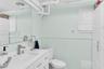 Bathroom featuring a white vanity with an integrated sink, polished metal faucet, full-width wall mirror, and built-in storage cabinetry
