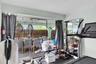 Large glass sliding doors opening to a covered patio featuring arched architectural details and tile flooring