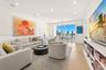 Living space featuring white-oak engineered wood flooring, recessed lighting, integrated ceiling speakers, built-in shelving, and floor-to-ceiling win